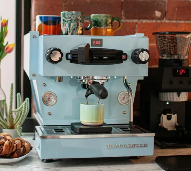 Sininen La Marzocco Linea Mini espressokone digitaalisella näytöllä ja tyylikkäällä ulkonäöllä.