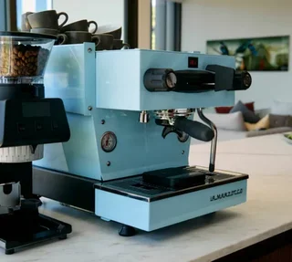 La Marzocco Linea Mini kék eszpresszógép digitális kijelzővel és modern dizájnnal.